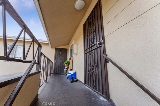 view of exterior entry featuring stucco siding and a balcony