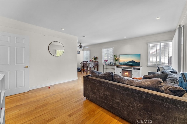living area featuring baseboards, recessed lighting, ceiling fan, and light wood-style floors