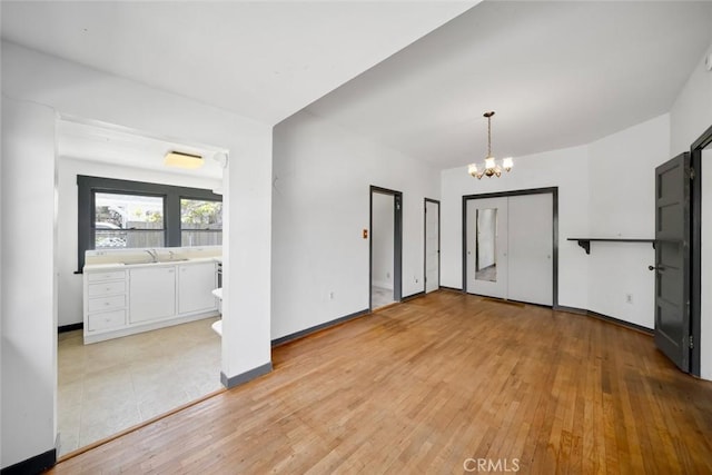 1811 Chorro St, San Luis Obispo, CA 93401 - interior space featuring baseboards, light wood-style floors, a sink, and an inviting chandelier