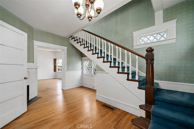 1811 Chorro St, San Luis Obispo, CA 93401 - stairway with a notable chandelier, wallpapered walls, visible vents, wainscoting, and wood finished floors