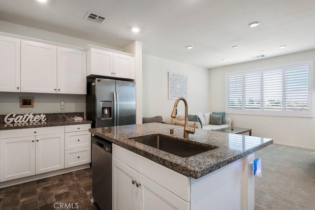 16540 Wyndham Ln Unit 10, Fontana, CA 92336 - kitchen featuring stainless steel appliances, a sink, dark stone counters, white cabinets, and a center island with sink