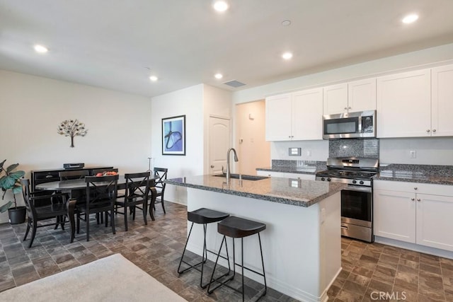 16540 Wyndham Ln Unit 10, Fontana, CA 92336 - kitchen featuring stainless steel appliances, a sink, stone finish floors, a center island with sink, and recessed lighting