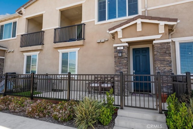 16540 Wyndham Ln Unit 10, Fontana, CA 92336 - view of exterior entry featuring stucco siding and stone siding