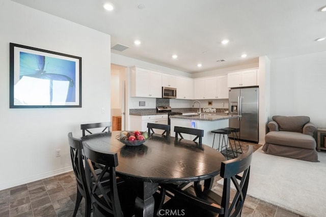 16540 Wyndham Ln Unit 10, Fontana, CA 92336 - dining area with baseboards, recessed lighting, and dark stone finish floors