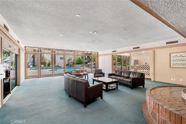 carpeted living area featuring a textured ceiling, wood walls, and visible vents