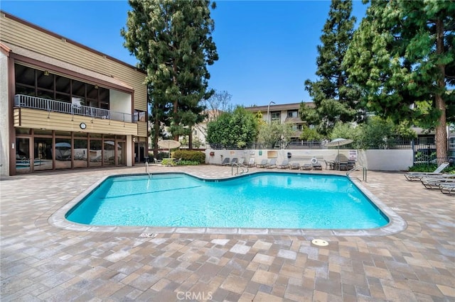 community pool featuring a patio area and fence