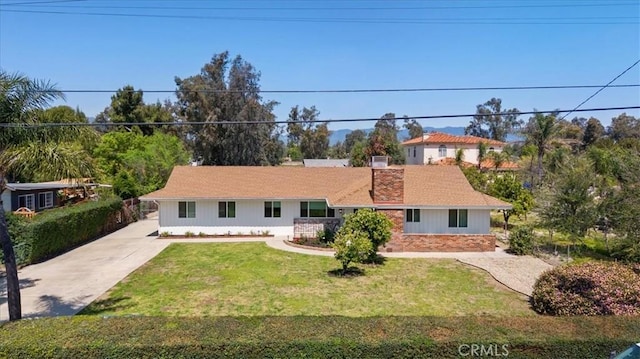 single story home featuring a front lawn and concrete driveway