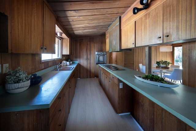 kitchen with light countertops, wood ceiling, stainless steel appliances, and a sink