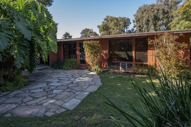 back of property featuring a patio area and a yard