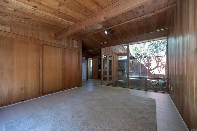 unfurnished living room featuring wood finished floors, wood walls, wood ceiling, and lofted ceiling with beams