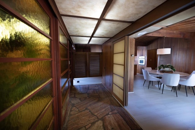 hallway featuring wood walls
