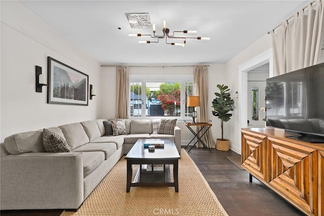 living area with baseboards, an inviting chandelier, and dark wood-type flooring