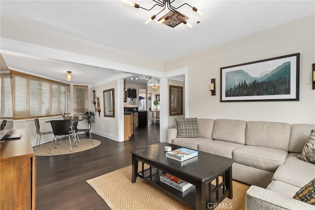 living area featuring an inviting chandelier, wood finished floors, and baseboards