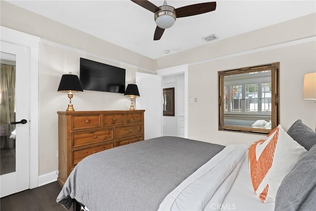 bedroom with dark wood-style flooring, visible vents, and ceiling fan
