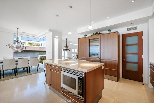 31091 Coast Hwy, Laguna Beach, CA 92651 - kitchen with visible vents, light countertops, a chandelier, brown cabinetry, and stainless steel microwave