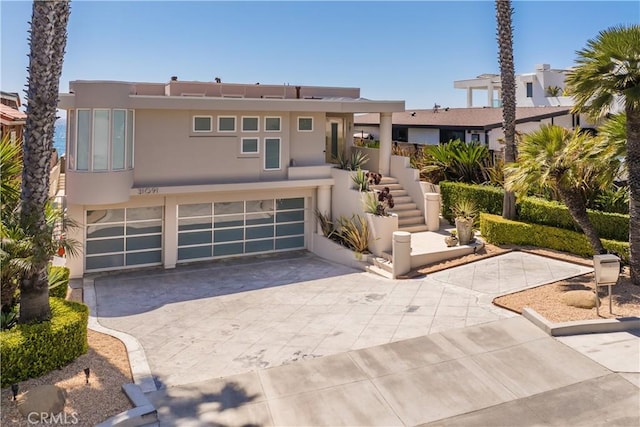 31091 Coast Hwy, Laguna Beach, CA 92651 - view of front of house featuring concrete driveway, stairway, stucco siding, and an attached garage