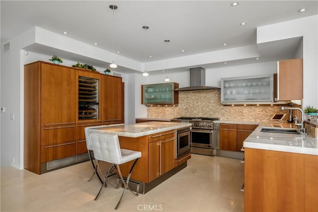 31091 Coast Hwy, Laguna Beach, CA 92651 - kitchen featuring a kitchen breakfast bar, brown cabinetry, wall chimney range hood, a center island, and stainless steel appliances