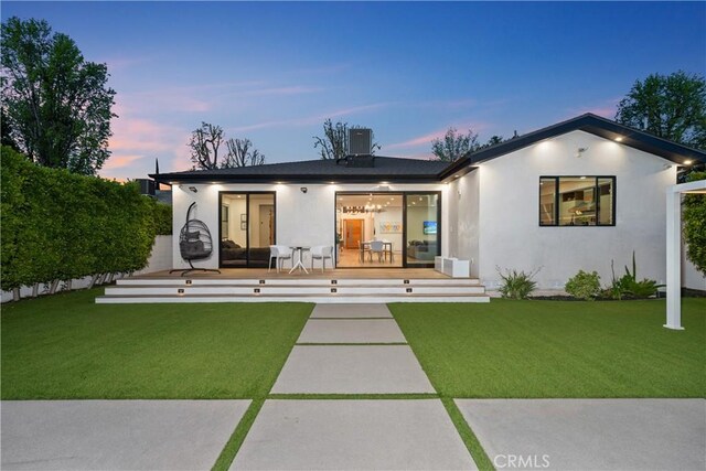 4739 Ventura Canyon Ave, Sherman Oaks, CA 91423 - back of property featuring stucco siding, a deck, a lawn, and central air condition unit