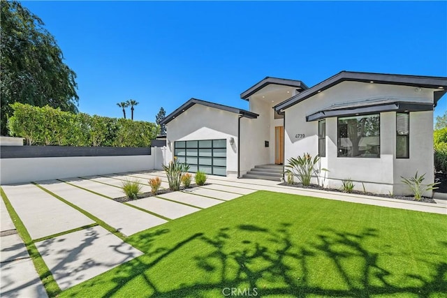 4739 Ventura Canyon Ave, Sherman Oaks, CA 91423 - view of front facade featuring a front lawn, stucco siding, concrete driveway, an attached garage, and fence