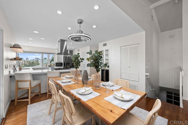 dining room featuring light wood finished floors, baseboards, visible vents, and recessed lighting