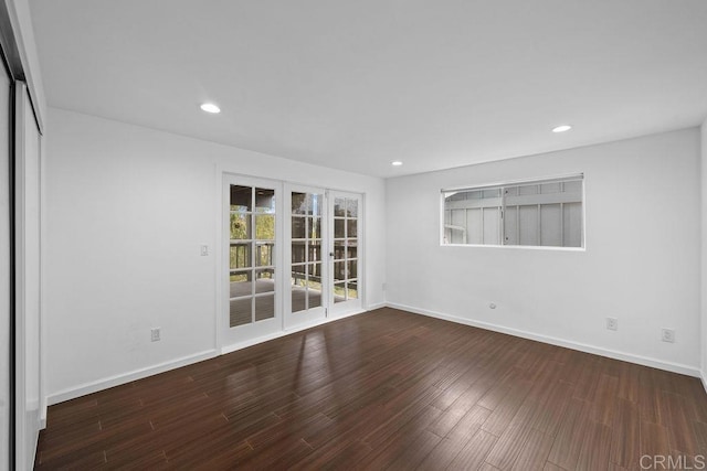 spare room featuring baseboards, wood finished floors, and recessed lighting