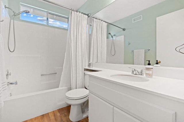 full bathroom featuring visible vents, shower / bath combination with curtain, toilet, vanity, and wood finished floors