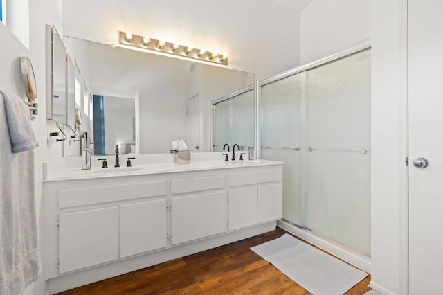 bathroom featuring a sink, a shower stall, and double vanity