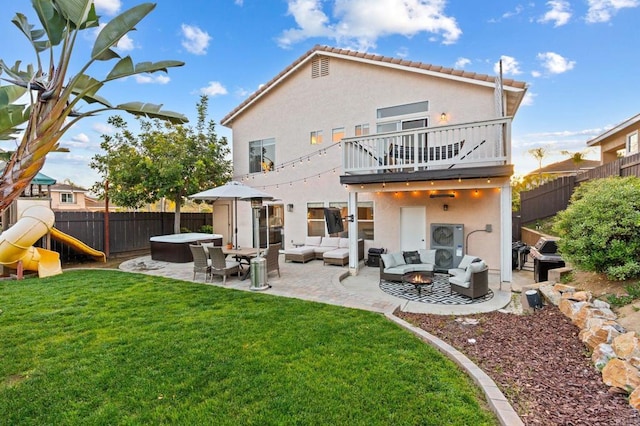rear view of property with an outdoor living space, a yard, and a patio area