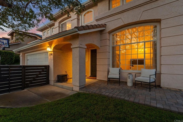 exterior space featuring a patio, a garage, and stucco siding