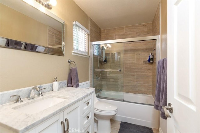 full bath featuring bath / shower combo with glass door, vanity, and toilet