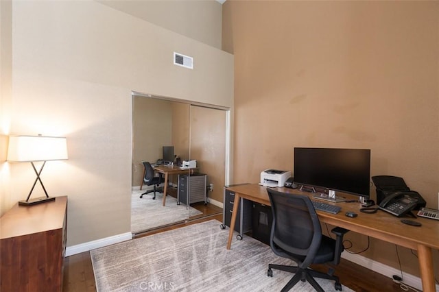 office featuring visible vents, baseboards, and wood finished floors