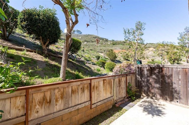 view of yard with a mountain view and fence