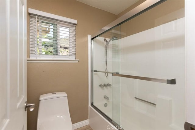 full bathroom featuring enclosed tub / shower combo, baseboards, and toilet
