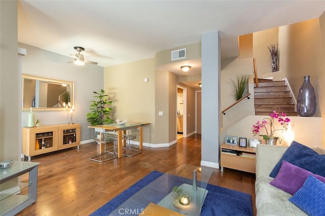 living room with baseboards, wood-type flooring, a ceiling fan, and visible vents