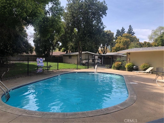 view of pool featuring a yard, fence, a fenced in pool, and a patio area