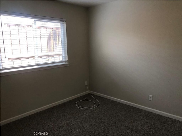 carpeted spare room featuring baseboards