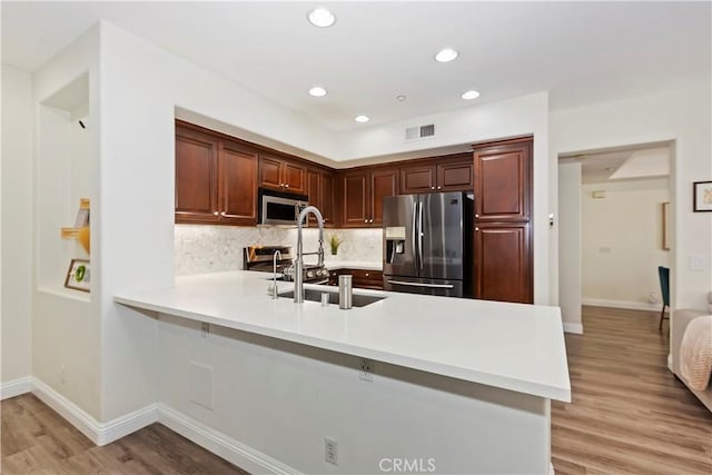 374 Quail Rdg, Irvine, CA 92603 - kitchen featuring stainless steel appliances, a peninsula, light countertops, light wood-type flooring, and recessed lighting