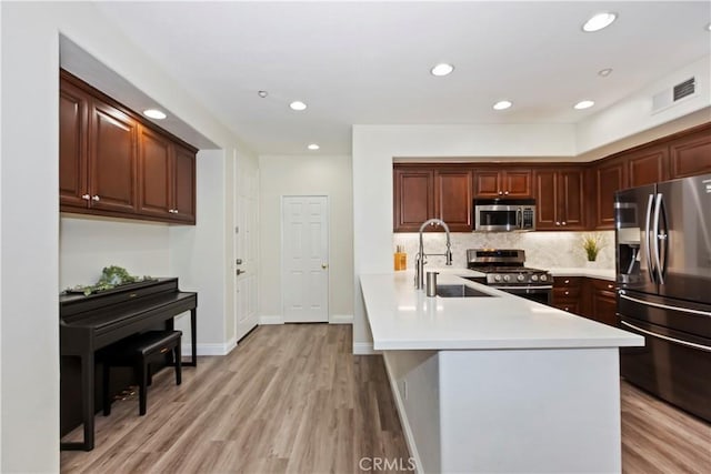 374 Quail Rdg, Irvine, CA 92603 - kitchen with appliances with stainless steel finishes, light countertops, light wood-style flooring, tasteful backsplash, and a peninsula
