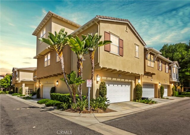 374 Quail Rdg, Irvine, CA 92603 - view of front facade featuring a garage, stucco siding, and concrete driveway