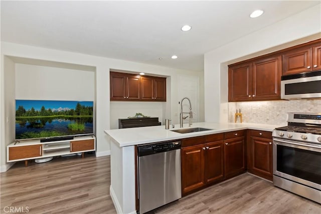 374 Quail Rdg, Irvine, CA 92603 - kitchen featuring appliances with stainless steel finishes, light countertops, a peninsula, light wood-type flooring, and recessed lighting