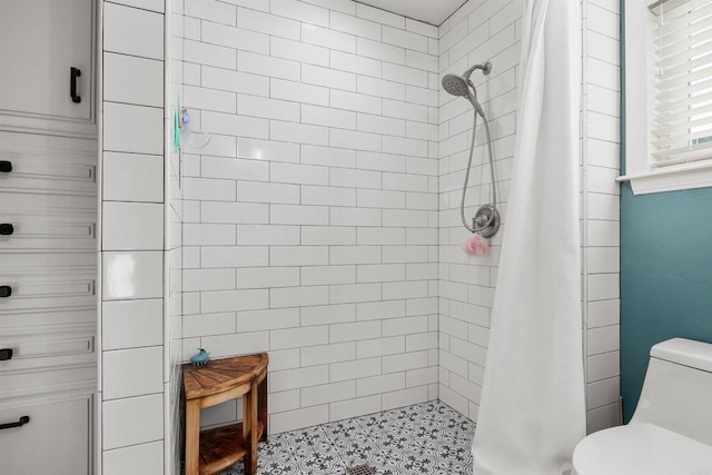 bathroom featuring toilet and a shower stall