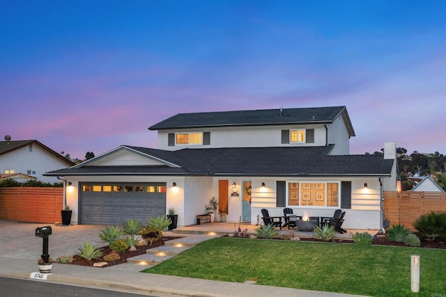 traditional-style home featuring a yard, driveway, fence, and a garage