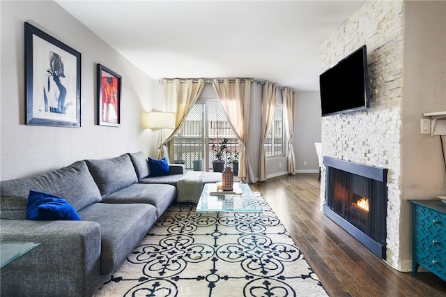 living area with wood finished floors, a fireplace, and baseboards