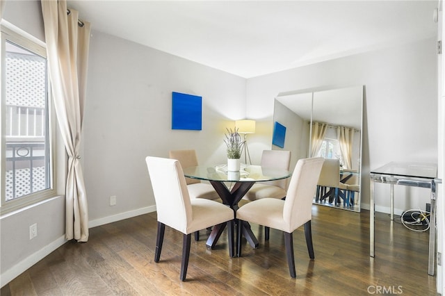 dining space featuring baseboards and wood finished floors