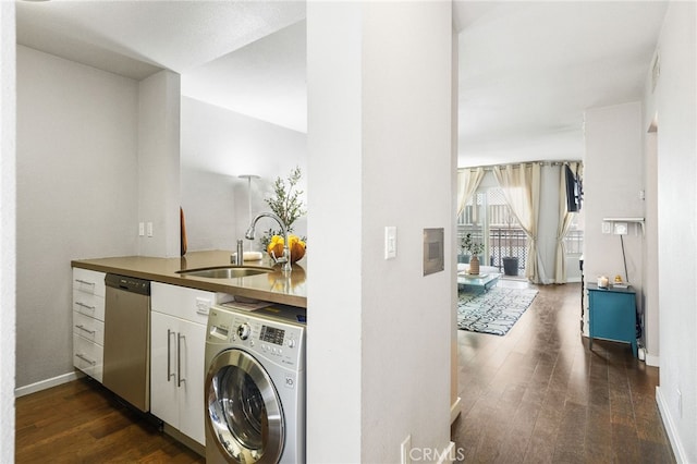 laundry area featuring a sink, baseboards, washer / dryer, and dark wood finished floors