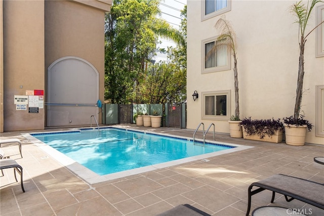 pool with fence and a patio