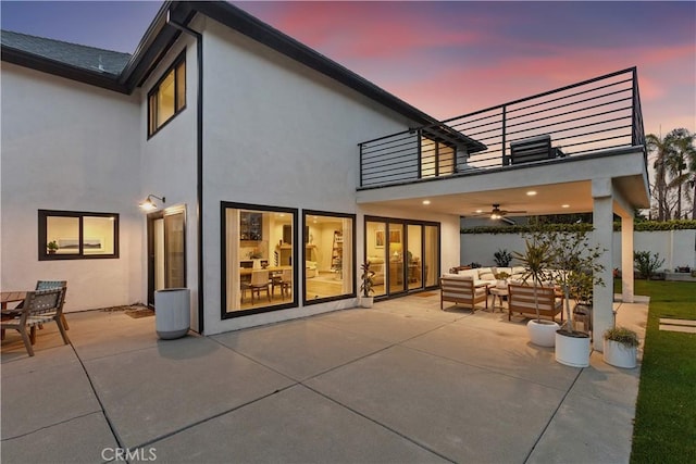 32152 Via Carlos, San Juan Capistrano, CA 92675 - back of property at dusk featuring a balcony, an outdoor living space, a ceiling fan, stucco siding, and a patio