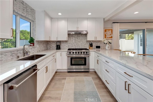 32152 Via Carlos, San Juan Capistrano, CA 92675 - kitchen featuring appliances with stainless steel finishes, under cabinet range hood, white cabinetry, light stone countertops, and tasteful backsplash