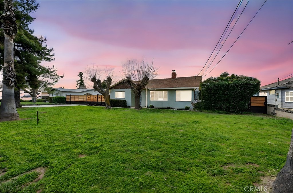 916 Stearns St, Calimesa, CA 92320 - view of front facade featuring fence, a lawn, and a chimney