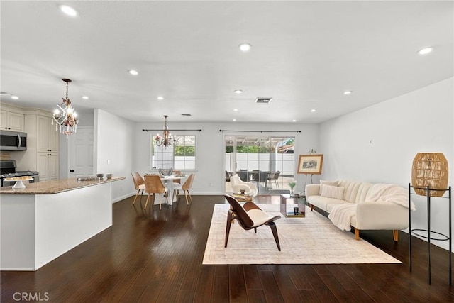 living room featuring a chandelier, visible vents, dark wood-style floors, baseboards, and recessed lighting